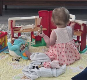 baby playing with farmhouse